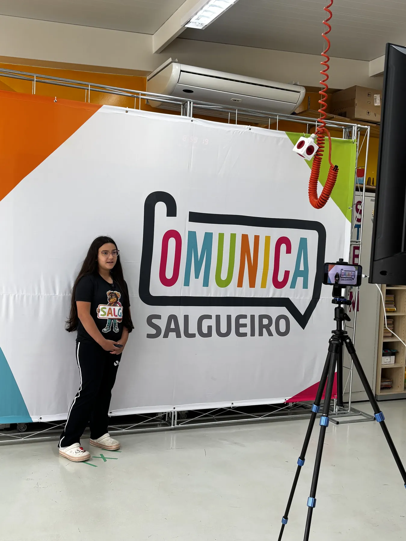 Estudante apresenta seu trabalho na frente do painel do Comunica Salgueiro