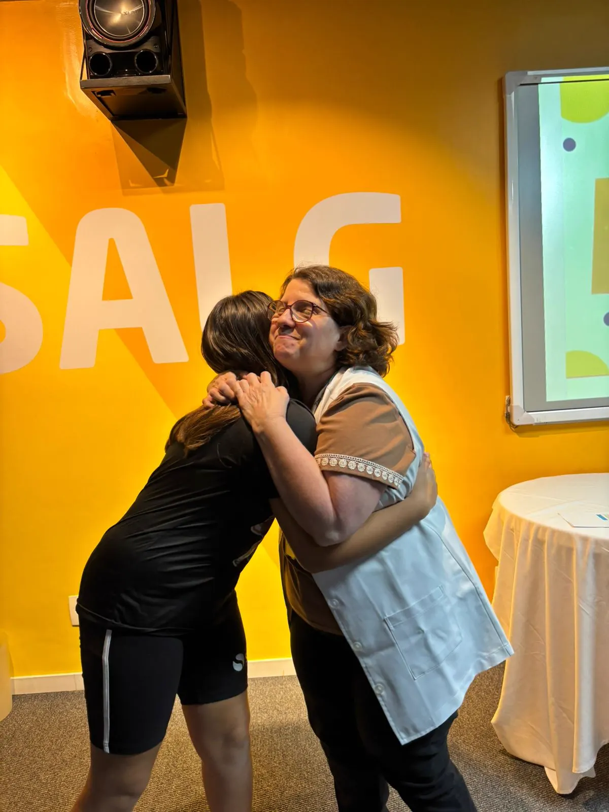 Professora abraçando aluna premiada na Olimpíada Canguru de Matemática