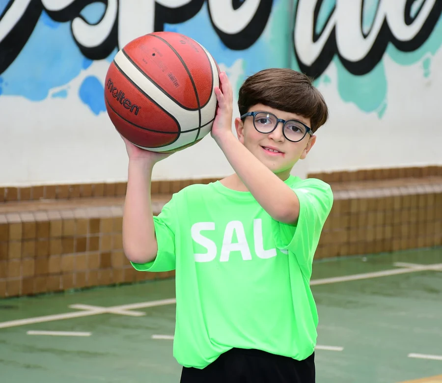 Aluno do Colégio Salgueiro arremessando bola de basquete